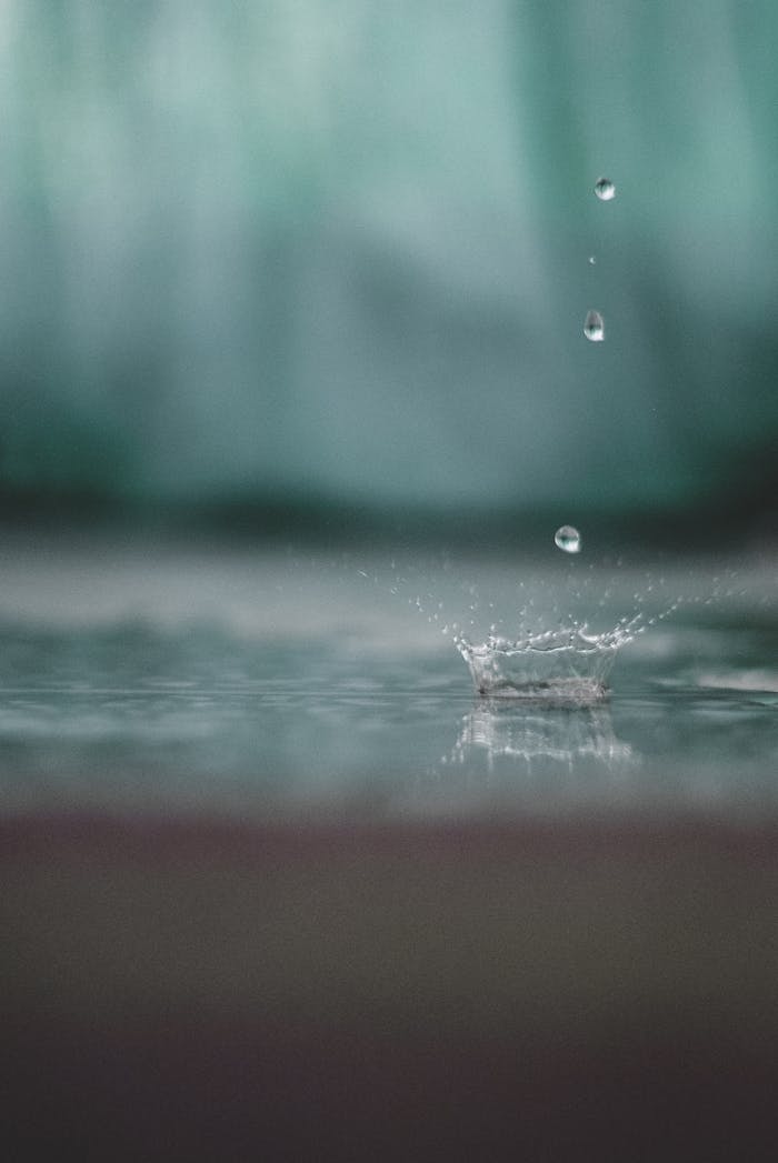 Close-up of a raindrop splash, capturing pure water droplets in motion outdoors.